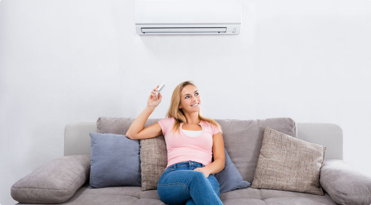 Woman with AC remote stock image
