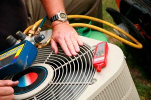 HVAC technician placing hand over an HVAC system while performing maintenance